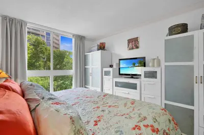 a bedroom with a bed and a tv and a window at Bayshore Charm-Free Parking in Miami