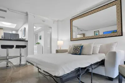 a white bedroom with a large mirror on the wall at Bayshore Charm-Free Parking in Miami