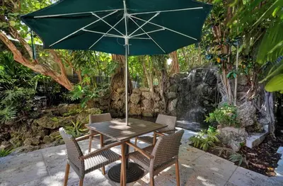 a table with a green umbrella and two chairs at Bayshore Charm-Free Parking in Miami