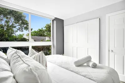a white bed in a room with a large window at Sunny Getaway, Pool and Parking in Miami