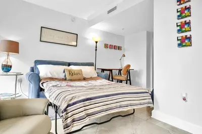 a bedroom with a bed with a striped blanket at Sunny Getaway, Pool and Parking in Miami