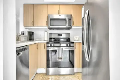 a kitchen with a stainless steel refrigerator and a microwave at Sunny Getaway, Pool and Parking in Miami