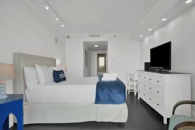 a bedroom with a bed and a desk with a tv at Coastal Elegance and Luxury by the Water in Miami