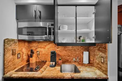a kitchen with a sink and a microwave at Grove Escape-Ocean Glimpse in Miami