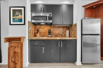 a kitchen with gray cabinets and stainless steel appliances at Grove Escape-Ocean Glimpse in Miami