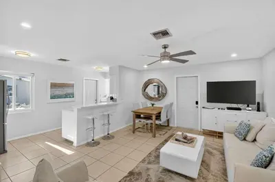 a living room with a couch and a flat screen tv at Victoria Park's Secret Estate in Fort Lauderdale