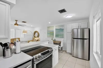 a kitchen with white cabinets and a stainless steel refrigerator at Victoria Park's Secret #2 - 6ppl in Fort Lauderdale