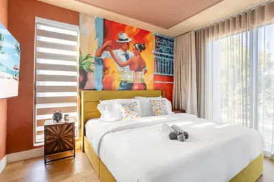 a bedroom with a large bed with a painting on the wall at 3BR Vibrant Havana Villa in Miami, Pool, Grill, Backyard in Miami