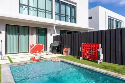 a house with a swimming pool and a red chair at 3BR Vibrant Havana Villa in Miami, Pool, Grill, Backyard in Miami