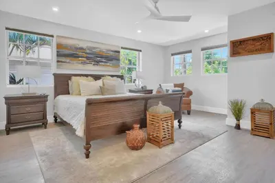 a bedroom with a bed and a table and windows at Home Away From Home in Coconut Grove in Miami