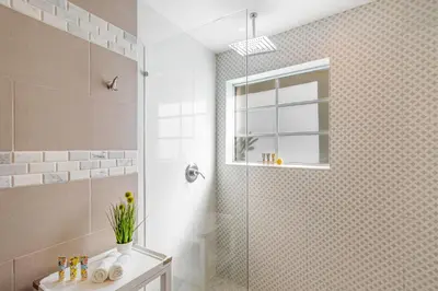 a bathroom with a shower with a glass door at Henrosa Hotel in Miami Beach