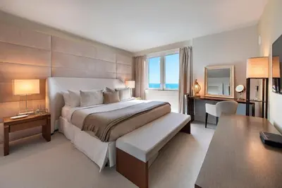 a bedroom with a large bed with a desk and a desk at Lumina Residences 2BR Skyline Escape in Miami Beach