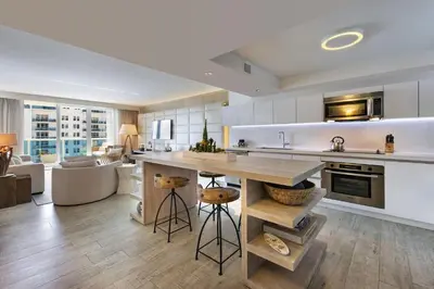 a kitchen with white cabinets and a large kitchen island at Lumina Residences 2BR Skyline Escape in Miami Beach