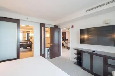 a bedroom with a large flat screen tv on a wall at Fontainebleau Sorrento Jr suite in Miami Beach