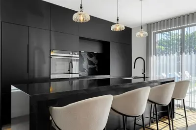 a kitchen with black walls and a counter with chairs at Parisian Vibe in Design District Miami with Private Pool BBQ Spacious Backyard in Miami
