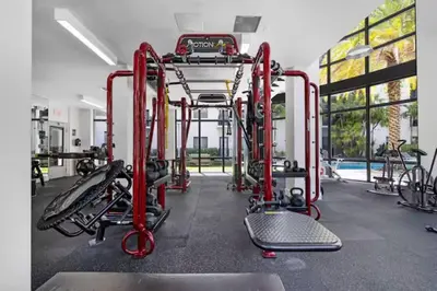 a gym with red equipment in front of a pool at Aqua Luxe in DTWN 3 Min From Las Olas in Fort Lauderdale