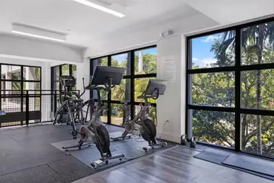 a gym with tread machines and large windows at Aqua Luxe in DTWN 3 Min From Las Olas in Fort Lauderdale