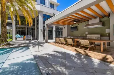 a patio with a table and chairs and a pool at Aqua Luxe in DTWN 3 Min From Las Olas in Fort Lauderdale