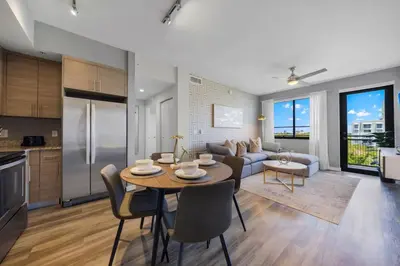 a kitchen and living room with a table and a couch at Casa Palmera in DTWN 3 Min From Las Olas in Fort Lauderdale