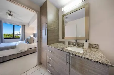 a bathroom with a sink and a bed and a mirror at Prestige Living in DTWN 3 Min From Las Olas in Fort Lauderdale