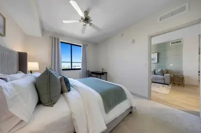 a bedroom with a large bed with a ceiling fan at Modern Palmera in DTWN 3 Min From Las Olas in Fort Lauderdale