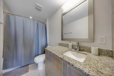 a bathroom with a sink and a toilet and a mirror at Serene Bleu in DTWN 3 Min From Las Olas in Fort Lauderdale