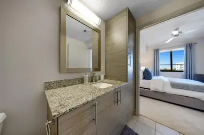 a bathroom with a sink and a bedroom with a bed at Serene Bleu in DTWN 3 Min From Las Olas in Fort Lauderdale
