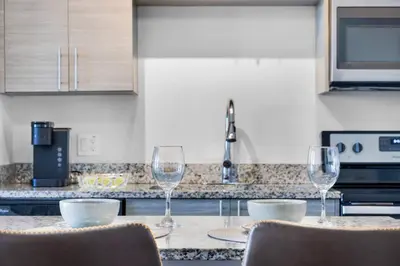 a kitchen with three wine glasses on a counter at The Serenity in DTWN 3 Min From Las Olas in Fort Lauderdale