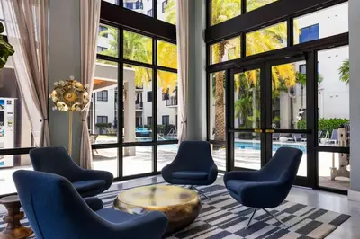 a lobby with chairs and a table and windows at The Serenity in DTWN 3 Min From Las Olas in Fort Lauderdale