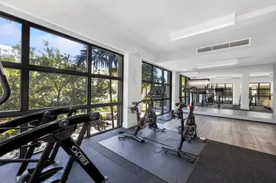 an image of a gym with treadmills and ellipticals at Palm Paradise in DTWN 3 Min From Las Olas in Fort Lauderdale
