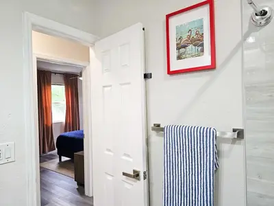 a bathroom with a white door and a picture on the wall at The Ruby - Hot Tub - King beds - Close to LMC in Fort Lauderdale
