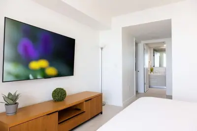 a bedroom with a television on a white wall at 2BR 2BA at Beachwalk on 29 floor Full Equiped in Hallandale Beach