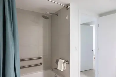 a bathroom with a shower with a blue shower curtain at 2BR 2BA at Beachwalk on 29 floor Full Equiped in Hallandale Beach