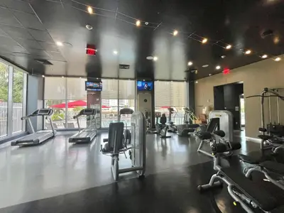 a gym with several treadms and cardio machines at Family Beachwalk Studio- 29th floor in Hallandale Beach