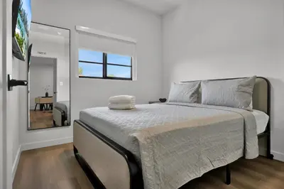 a white bedroom with a large bed with a window at Prestige Retreat by Renzzi in Miami