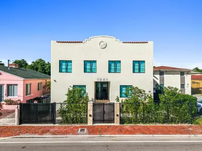 a white house with a clock on the side of it at Prestige Retreat by Renzzi in Miami
