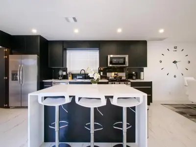 a kitchen with a white counter and a large clock at Luxury,3Bed 2Bath ,Pool,Grill,Parking in Hollywod in Hollywood