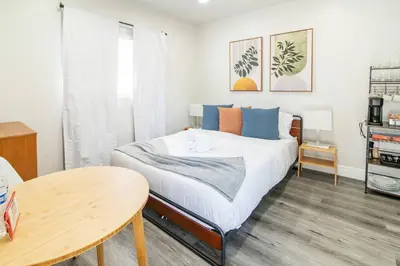 a small bedroom with a bed and a table at Cozy Modern Studio Near Sunny Isles & Bal Harbour in North Miami