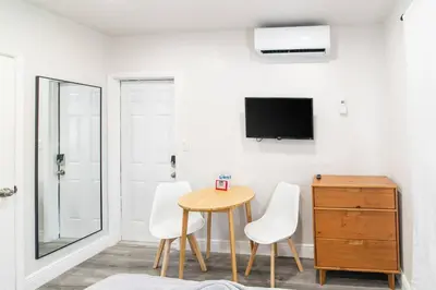 a room with a table and two chairs and a tv at Cozy Modern Studio Near Sunny Isles & Bal Harbour in North Miami