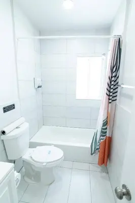 a white bathroom with a tub and a toilet at N. Miami Studio | Stylish Stay Minutes from Ocean in North Miami