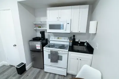 a kitchen with a stove and a microwave at N. Miami Studio | Stylish Stay Minutes from Ocean in North Miami