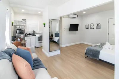 a living room with a couch and a bedroom at Modern Studio Apt • Prime North Miami Location in North Miami