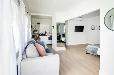 a person laying on a couch in a living room at Modern Studio Apt • Prime North Miami Location in North Miami