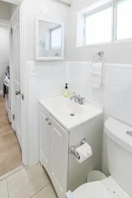 a white bathroom with a sink and a toilet at Modern Studio Apt • Prime North Miami Location in North Miami