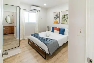a bedroom with a large bed and a mirror at Spacious 1BR in North Miami | Near Beach & Dining in North Miami