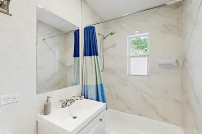 a white bathroom with a sink and a shower at Palm & Pool Retreat in Fort Lauderdale