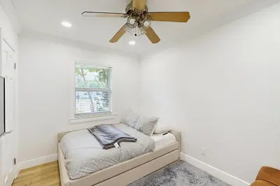 a bedroom with a ceiling fan and a couch at Palm & Pool Retreat in Fort Lauderdale