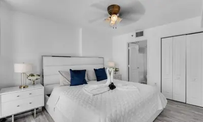 a white bedroom with a white bed with blue pillows at Skyline with Water views 2 bedroom in Miami
