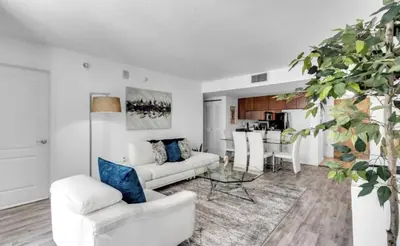 a living room with white furniture and a kitchen at Skyline with Water views 2 bedroom in Miami