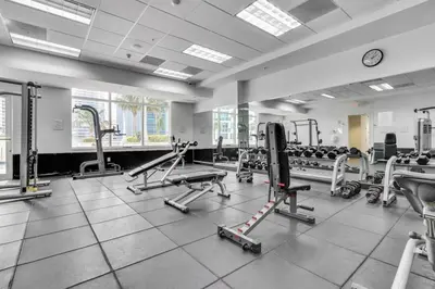 a gym with several tread machines and a clock at Stunning 3B2B with Ocean and City Views - Free Parking in Miami